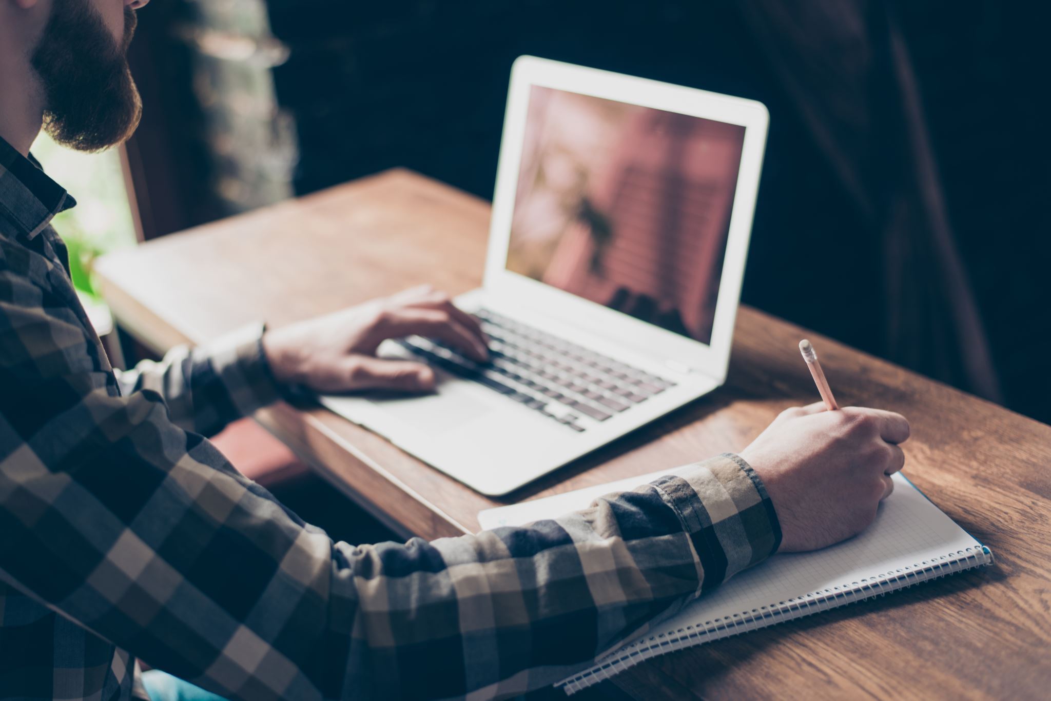Person-working-with-laptop-and-notepad